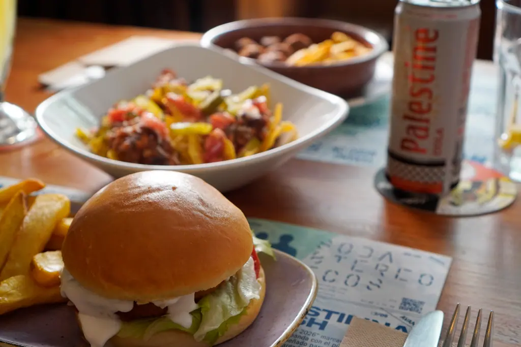 Hamburguesa vegana con patatas fritas en una mesa de Viva Chapata