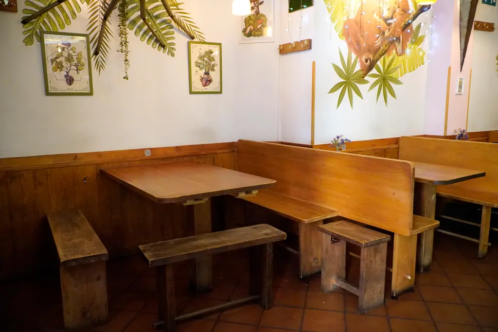 Mesas y bancos de madera vacíos en el comedor de Viva Chapata, esperando a los siguientes comensales